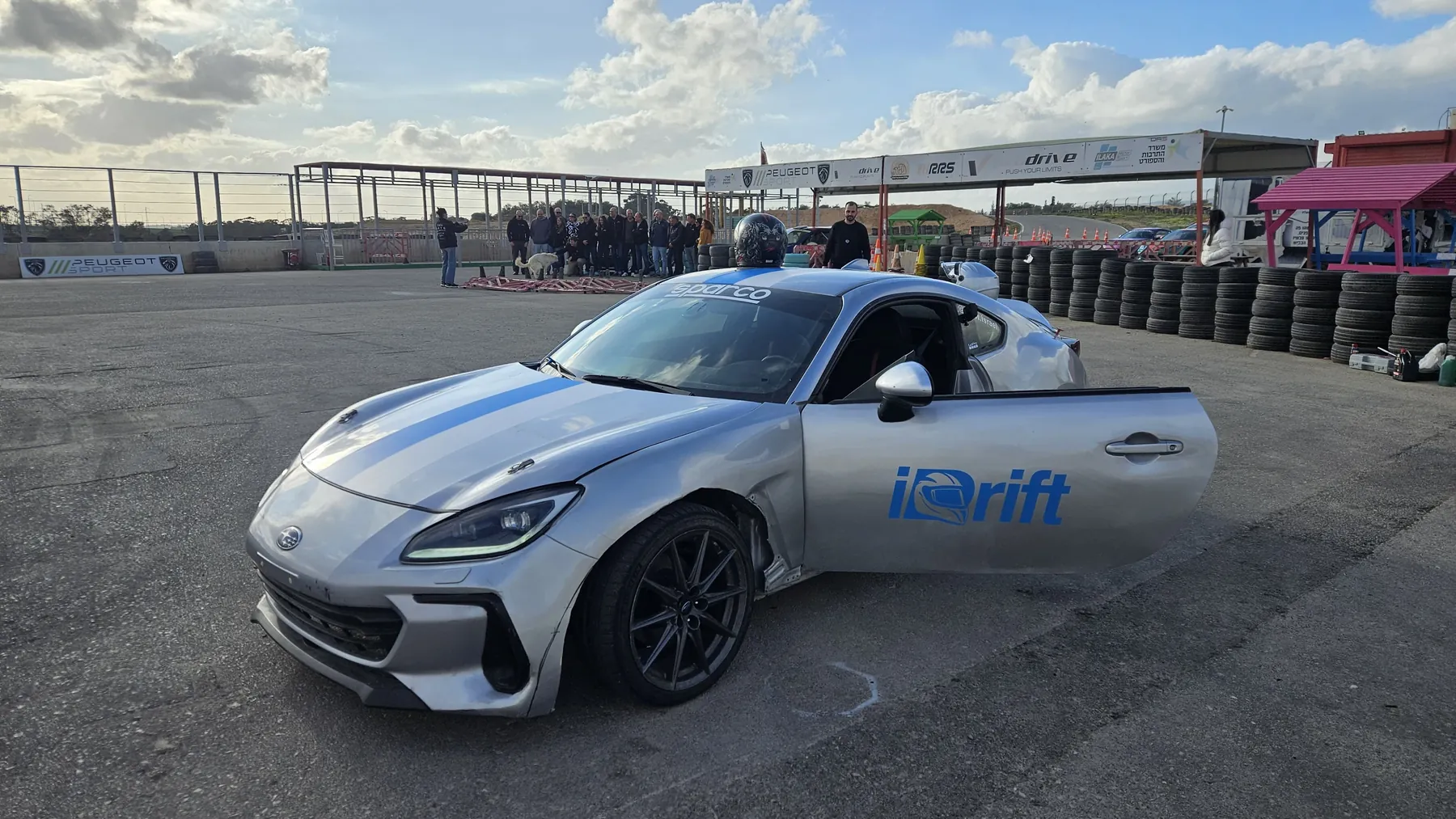 רכב הדריפט של iDrift במתחם, משתתפים ברקע
